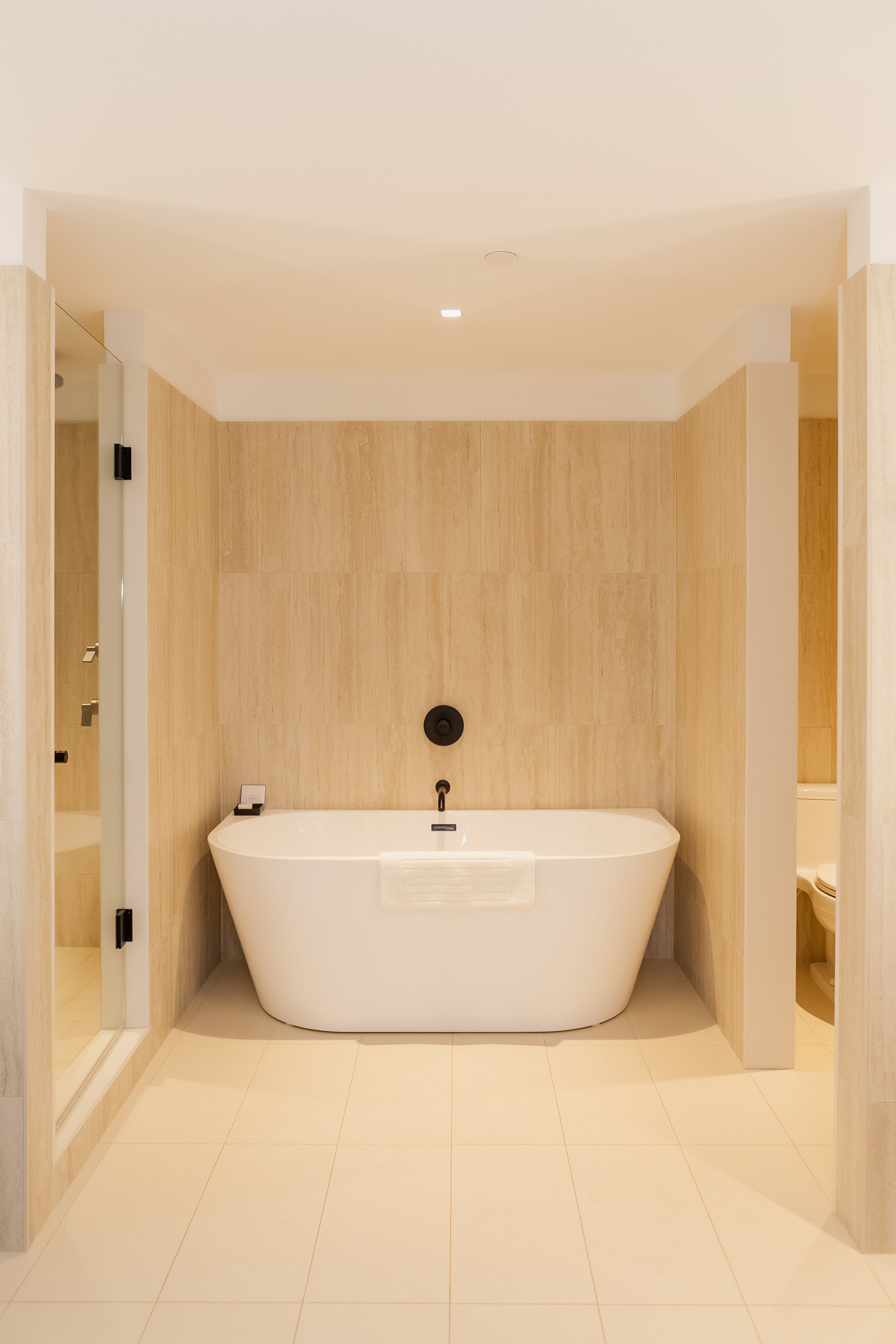 White freestanding tub with black hardware in elegant bathroom