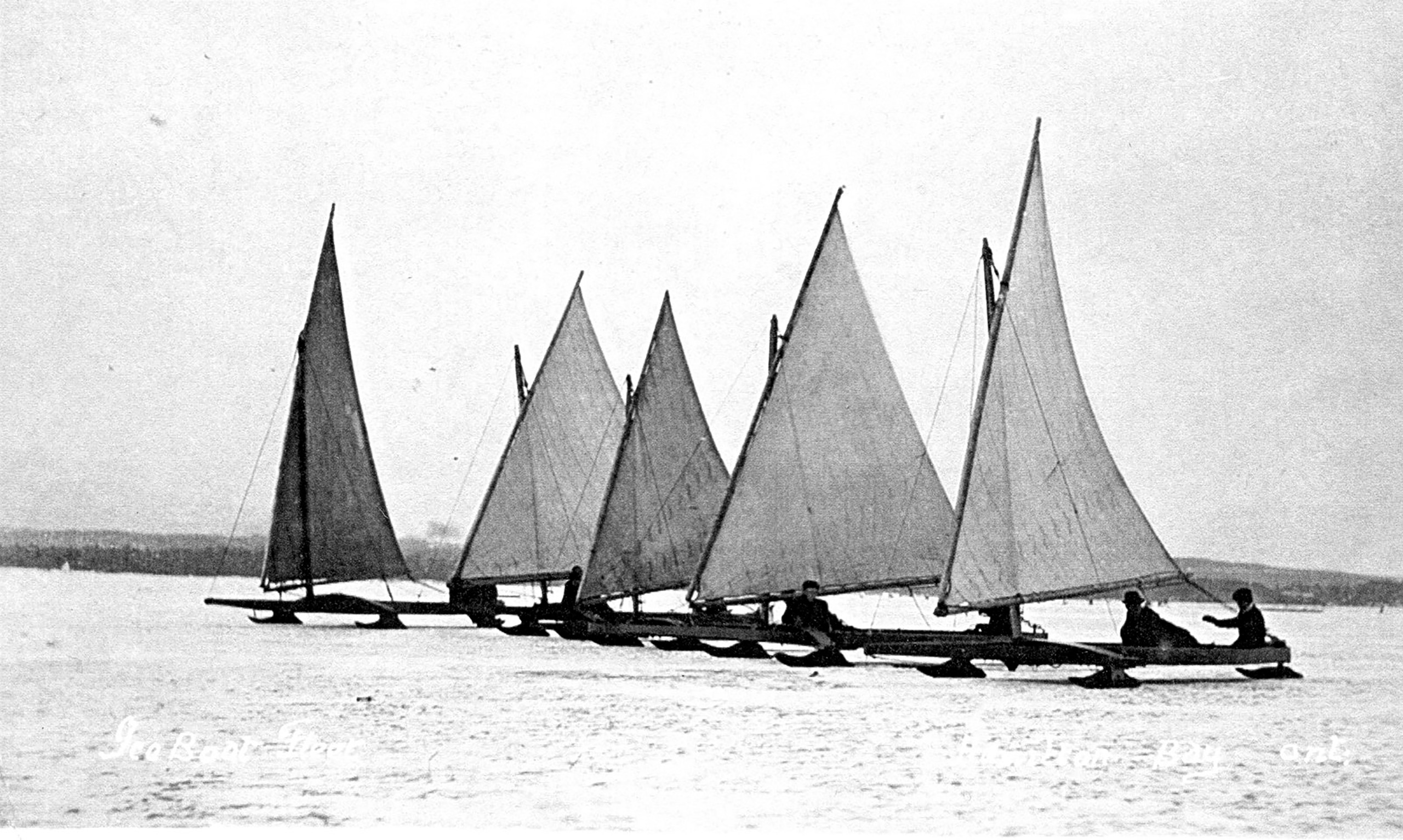 Black and white photo of people on sail boats