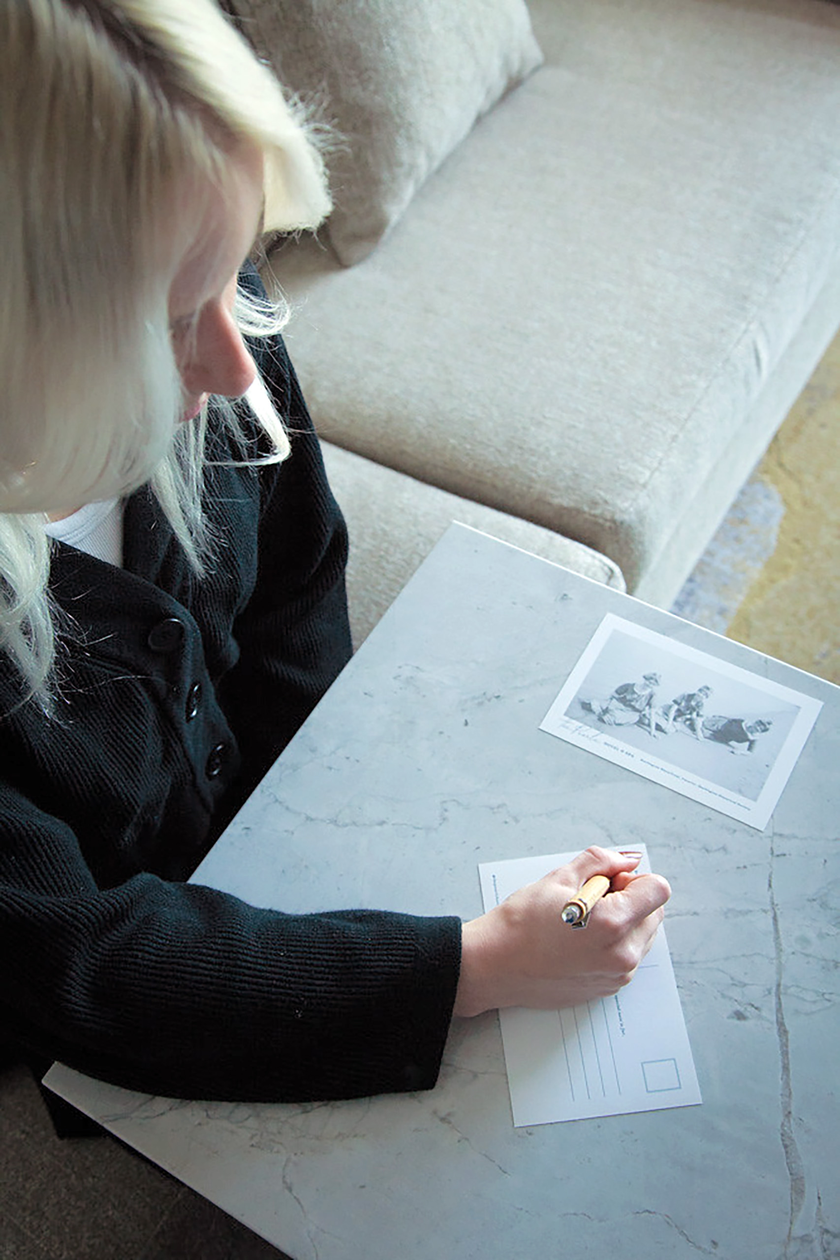 Blonde woman writing a letter for The Mark at The Pearle Hotel in Burlington Ontario