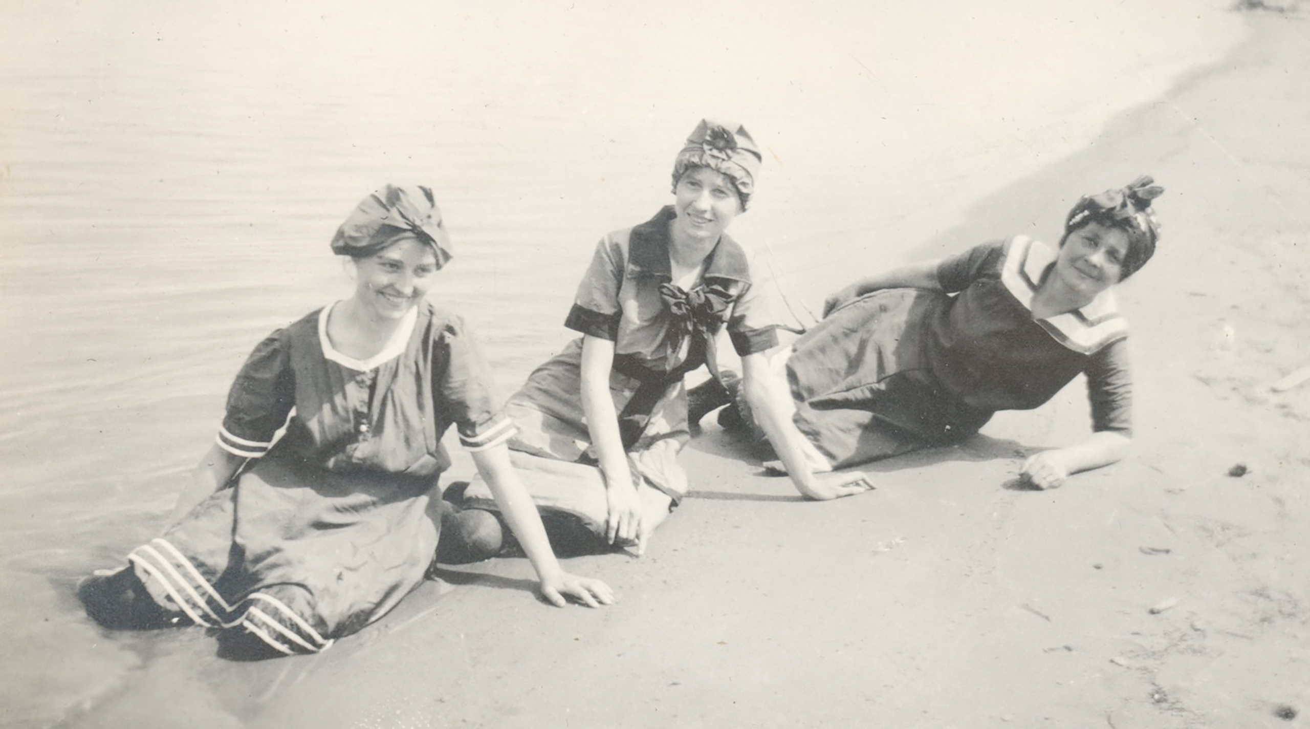 Historical photo of three women sitting on the beach