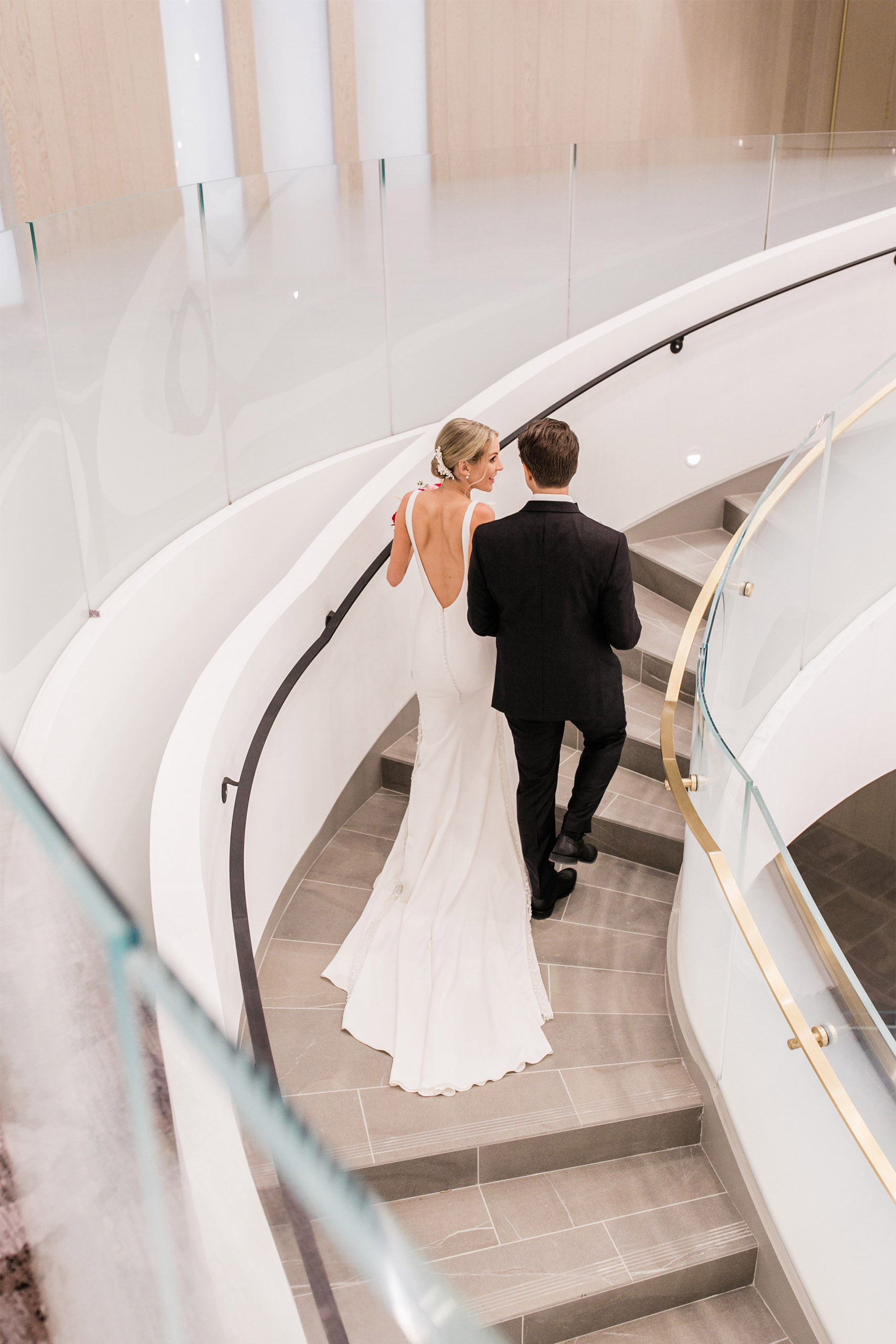 Bride and Groom walking up the lobby stairs at The Pearle Hotel in Burlington