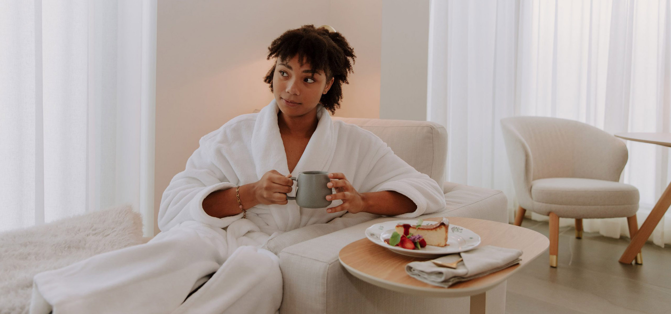 Woman sitting in a comfortable chair drinking a herbal tea