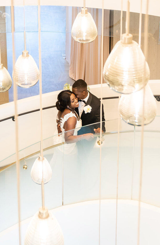 Bride and Groom standing on the staircase inside The Pearle Hotel lobby