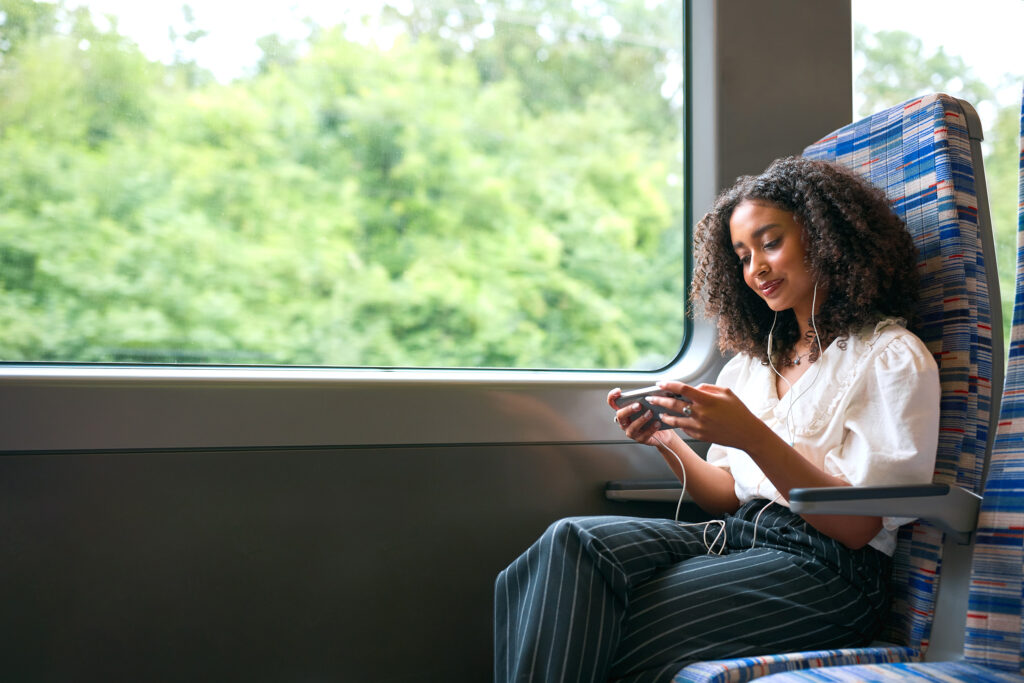 Woman sitting on the GO Train watching a video on her phone